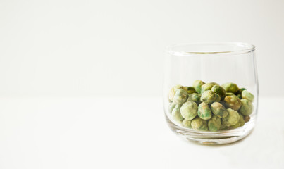 green roasted wasabi bean nuts dessert snack in a glass on white background.