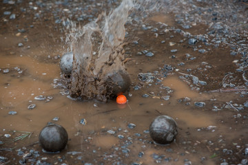 Petanque steel balls in mud.