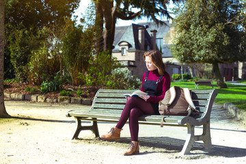 girl at the park reading a book