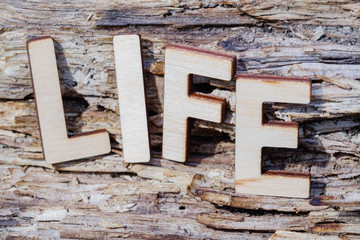 LIFE word wood letters, text on old wooden background, concept.