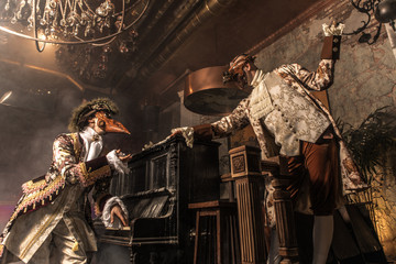 Actors in steam punk masks and antique costumes indoor.