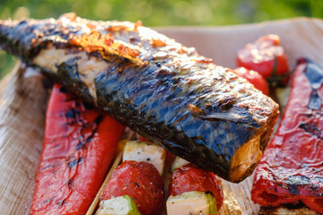 Grilled vegetable skewers and fish of mackerel in a herb marinade on a plate, onion, pepper zucchini tomato roasted barbecue