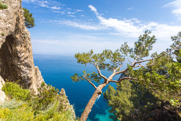 Fototapeta na wymiar Capri Italy, island in a beautiful summer day, with faraglioni rocks and natural stone arch.