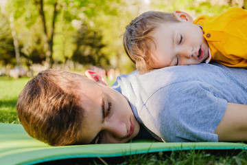 Cheerful two brothers sleep lie on the grass