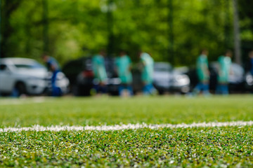 White stripe on Artificial green football soccer field from side view.