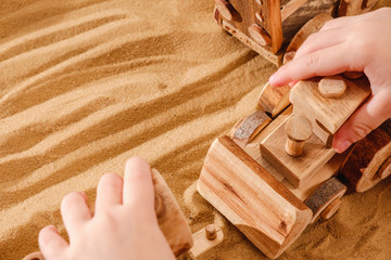 Toddler playing with wooden toy tractor bulldozer
