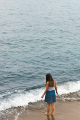 Girl walking into sea Italy