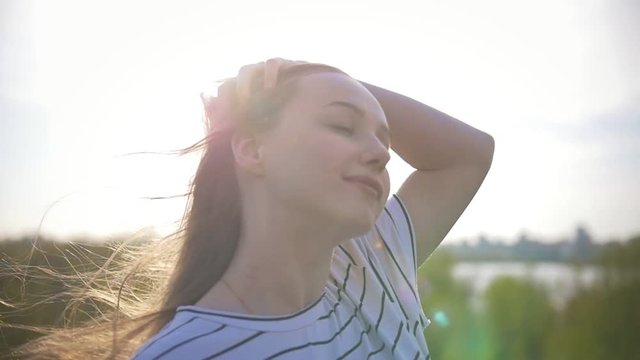 Portrait of happy young woman smiling at sunset