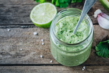 green salad dressing with avocado, lime and cilantro in a glass jar