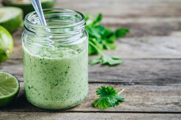green salad dressing with avocado, lime and cilantro in a glass jar © nblxer