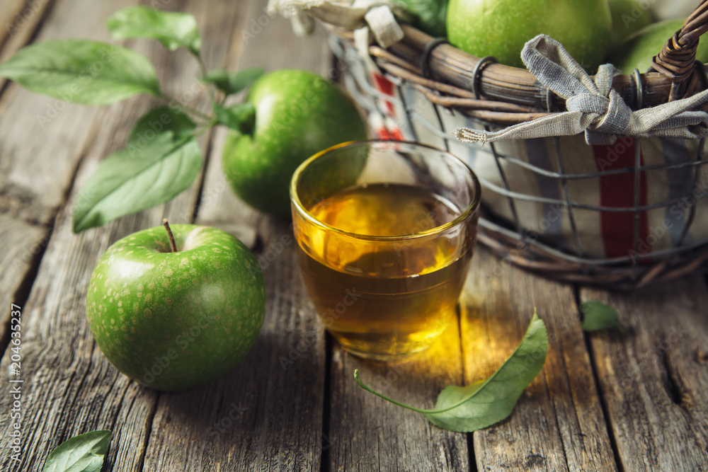 Wall mural Fresh apple juice and ripe fruits arranged on a vintage wooden background