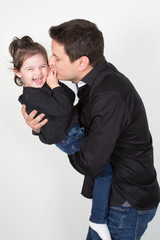 Father and daughter relations kiss play and smile in studio