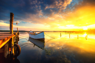 Fototapeta premium Small Dock and Boat at the lake, sunset shot