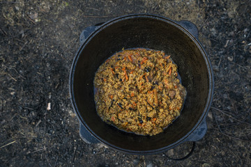 Pilaf in a large cauldron. Uzbek cuisine. Boiling rice. Traditional oriental dish.
