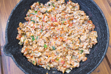 Appetizing fried minced meat with vegetables and greens in rustic old frying pan close-up
