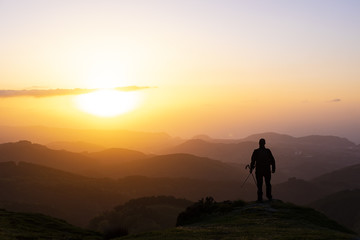 Obraz na płótnie Canvas Man on top of mountain at sunset. Conceptual scene.