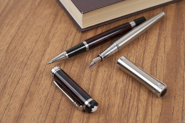 Notepad, pen and watches on the wood desk