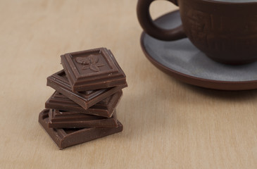 Chocolate and cup of coffee espresso on wood background