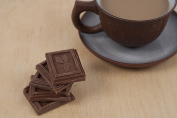 Chocolate and cup of coffee espresso on wood background