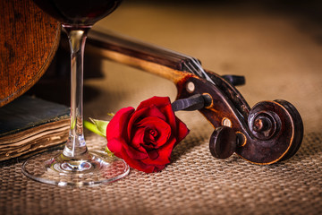 Violin scroll close with red rose