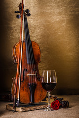 Red wine in glass and old violin