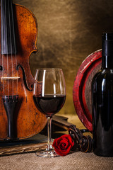 Red wine in glass, barell and violin