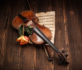 Old violin, bow and musical score with rose