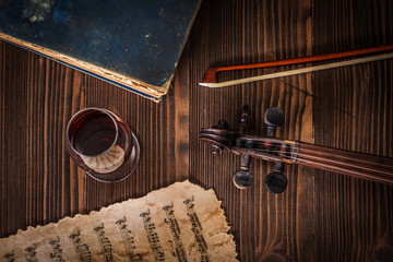 Top view about old book, violin scroll, bow and musical score