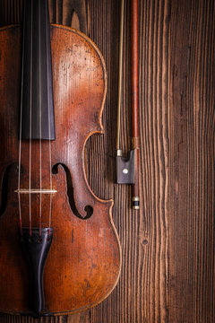 Violin detail with bow on wooden background