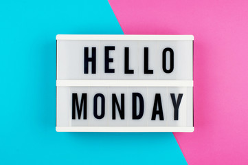 Hello Monday - text on a display lightbox on blue and pink bright background.