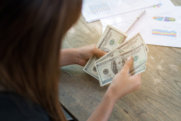 woman hands counting us dollar banknotes. She counts a lot of money.