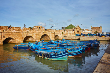 Fort of Essaouira in Morocco on a sunny day with blue boats on the water