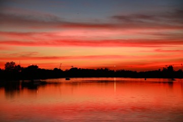Fototapeta premium After Sunset on the Ski Rixen Lake with Reddish Orange Clouds at Quiet Waters Park, Deerfield Beach, Florida