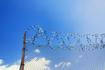 Barbed wire on blue sky background. 