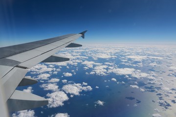 Looking Out Over the Wing of a Commercial Airline Jet to the Atlantic Seaboard over a Blanket of Scattered White Clouds