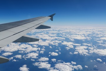 Looking Out Over the Wing of a Commercial Airline Jet to the Atlantic Seaboard over a Blanket of Scattered White Clouds