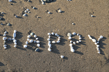 Fototapeta na wymiar Happy. Inscription on the beach 