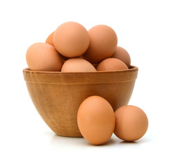 wood bowl with brown eggs over the white background