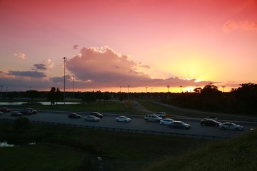 Rush Hour Traffic on the Florida Turnpike at the Sample Road Overpass in Pompano Beach at Sunset through Red Graduated Filter