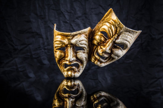 two theatrical masks are good and evil on a black background