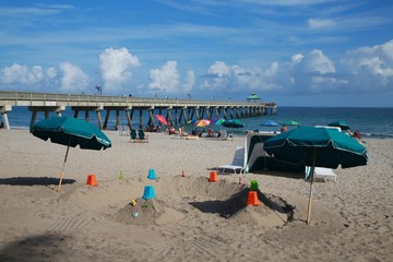 Various Color Shovels and Buckets Turned Upside Down on Sand Enclave in Deerfield Beach, Florida...