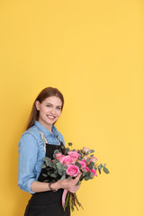 Female florist holding bouquet of beautiful flowers on color background