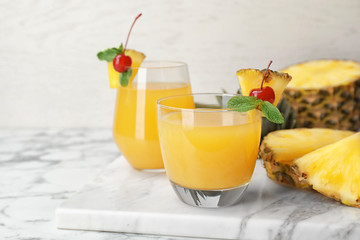 Glasses with delicious pineapple juice on table