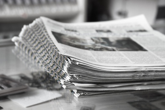 Stack of newspapers on the newspaper stand, close up