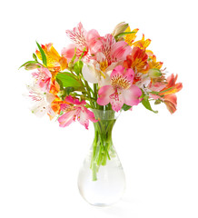 Bouquet of colorful  Alstroemeria flowers in a transparent glass vase isolated on white background.