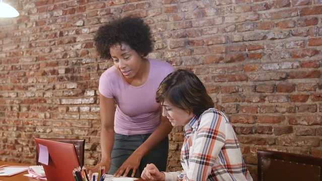 Small team working on computer in coworking space