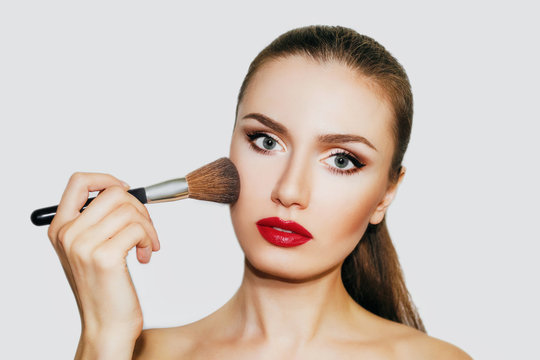 beautiful woman with beautiful make-up. Woman with a brush for make-up . Make-up artist
