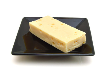 piece of cheese in plate on a white background