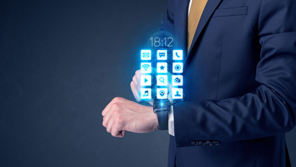 Businessman wearing smartwatch with application icons.