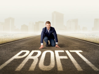 Young determined businessman kneeling before profit sign